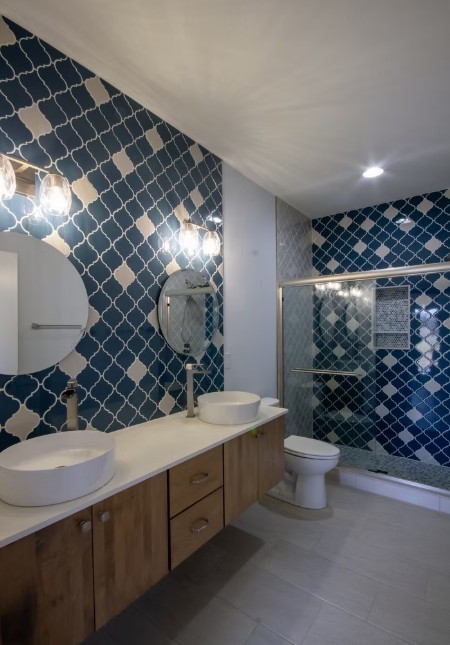 Finished hall bathroom with a blue arabesque tile feature wall, floating vanity, and custom glass shower