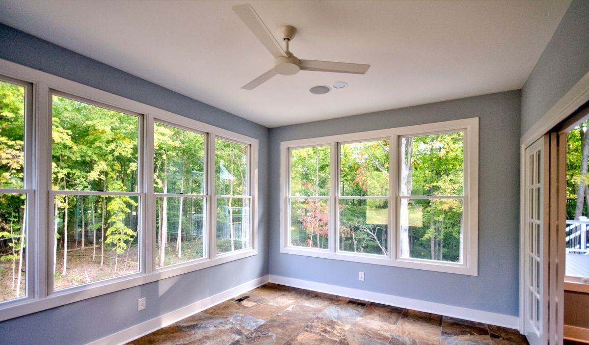 Slate-look porcelain floor tile in a sunroom with wooded views