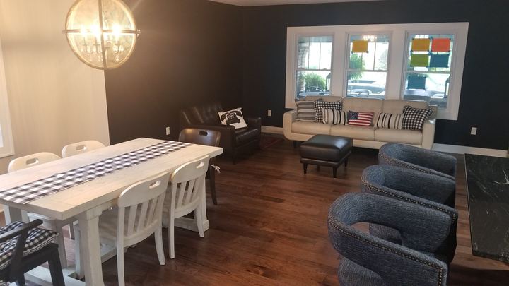 Hand-scraped hickory hardwood flooring in an open living and dining area with a dark accent wall