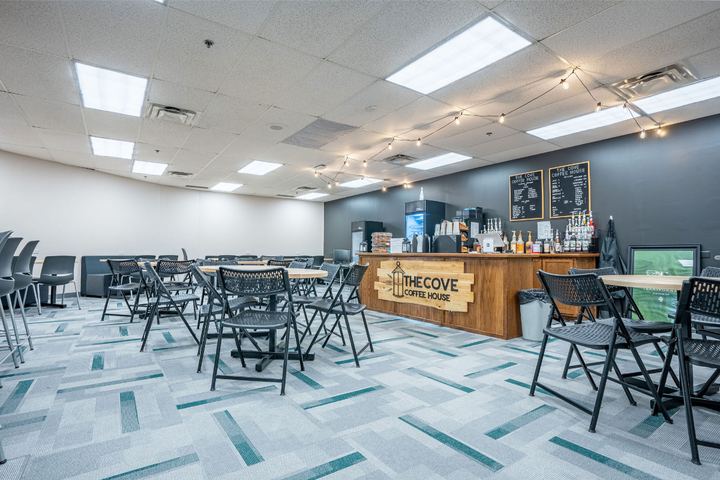 Commercial carpet tile in gray and teal geometric planks in a school coffee house seating area