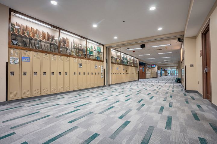 High school locker hallway with gray and teal patterned carpet tile flooring