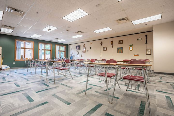 Commercial carpet tile in gray and teal geometric pattern installed in a school classroom