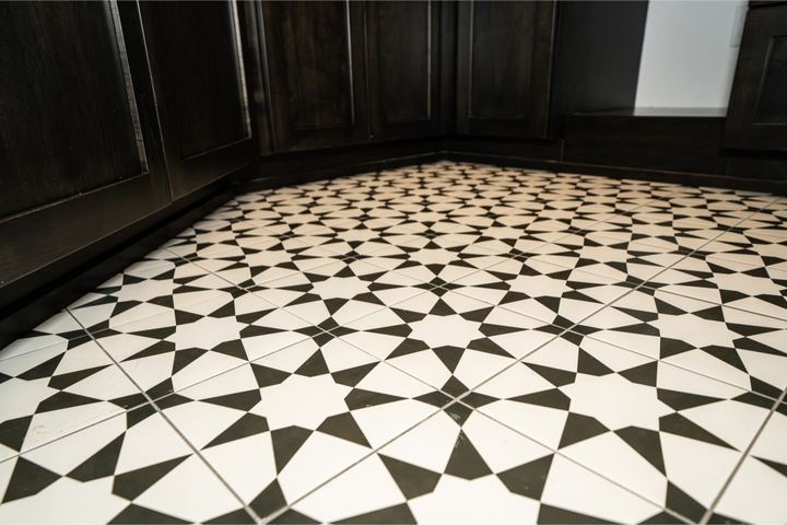 Black and white star-pattern ceramic tile floor beside dark shaker cabinetry