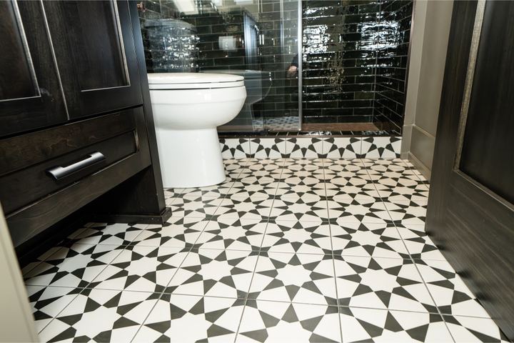 Black and white star-pattern porcelain tile bathroom floor with dark green subway shower and espresso cabinet