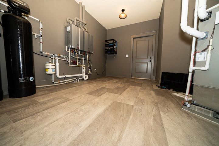 Stone-look luxury vinyl plank flooring in a finished basement mechanical and utility room