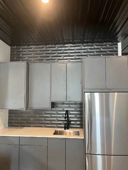 Gray kitchenette with dimensional 3D metallic tile backsplash, black ceiling and matte black faucet