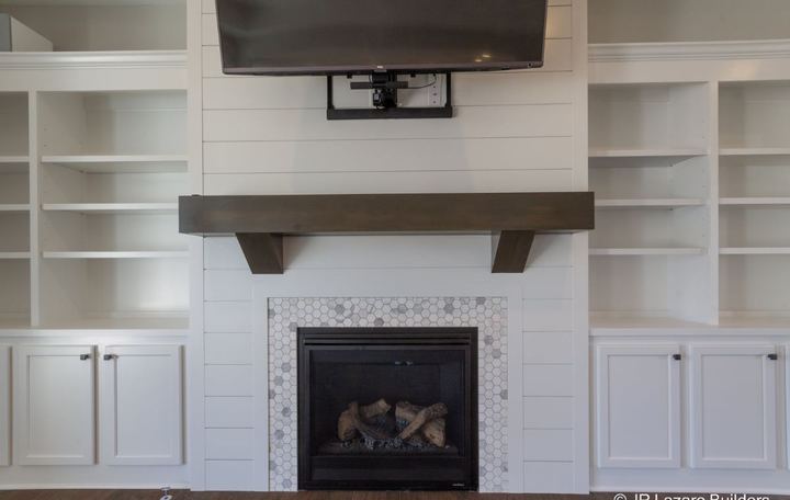 Marble hexagon tile fireplace surround with shiplap accent wall and rustic wood mantel