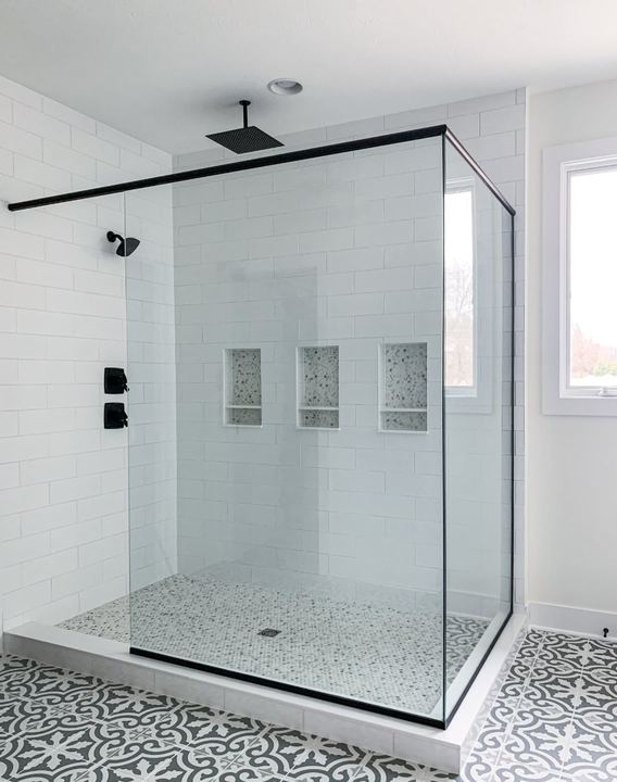 White subway tile walk-in shower with marble mosaic pan and gray patterned bathroom floor tile