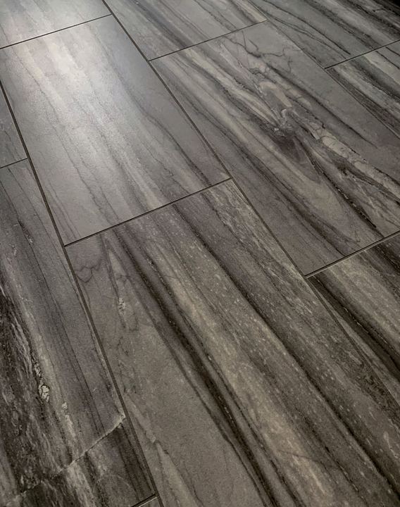 Closeup of gray marble-striated plank tile flooring in a master bathroom