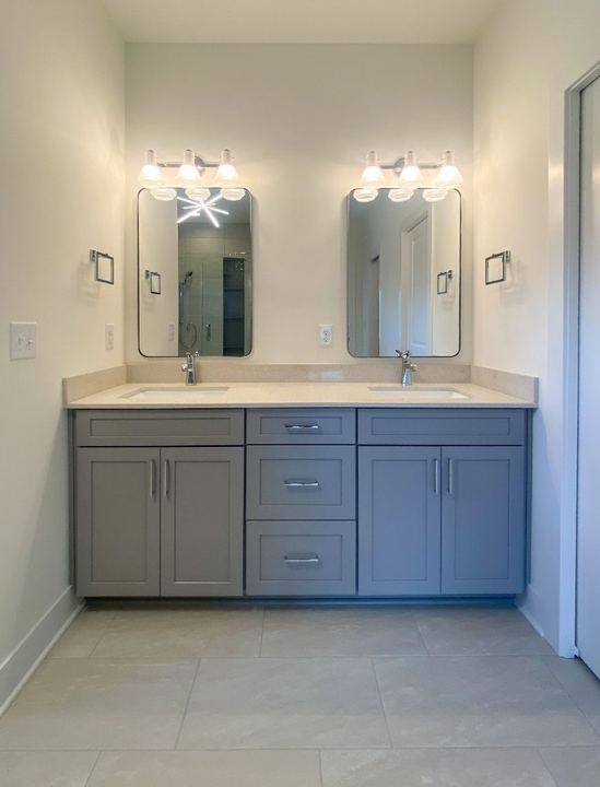 Master bathroom with 24x24 gray porcelain tile floor, double gray vanity and quartz countertop