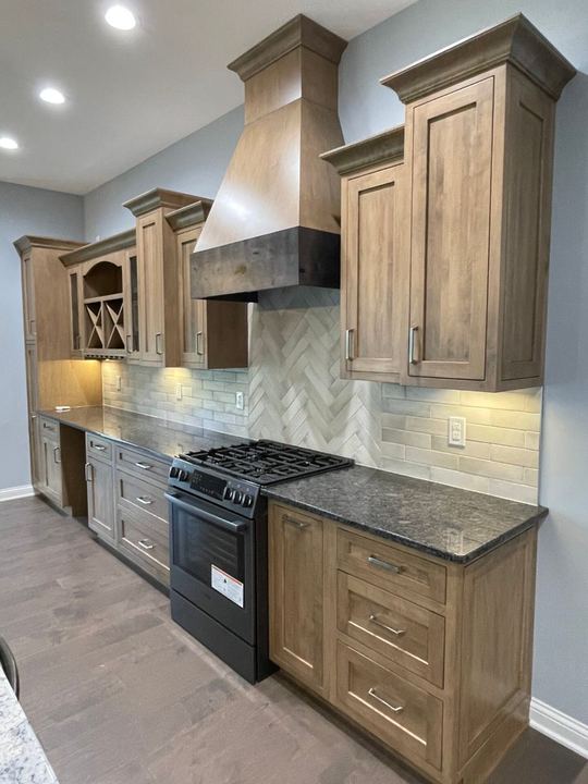 Kitchen backsplash with brick-look subway tile and herringbone accent behind the range