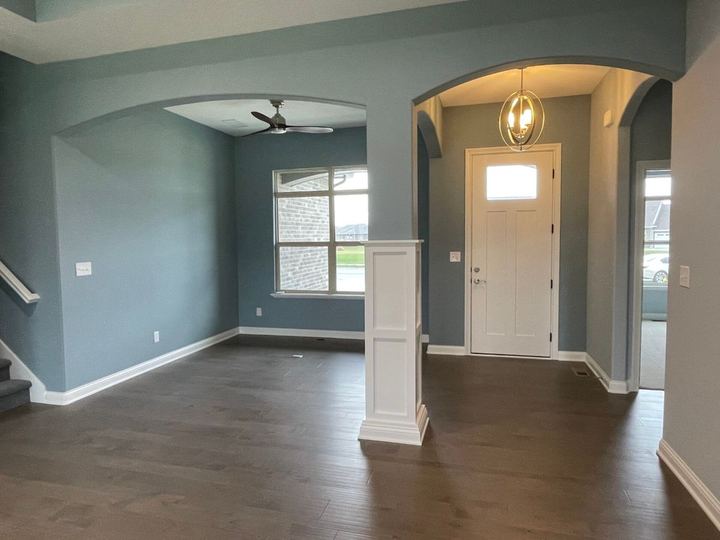 Dark stained maple hardwood flooring through an entry and dining room with blue-gray walls