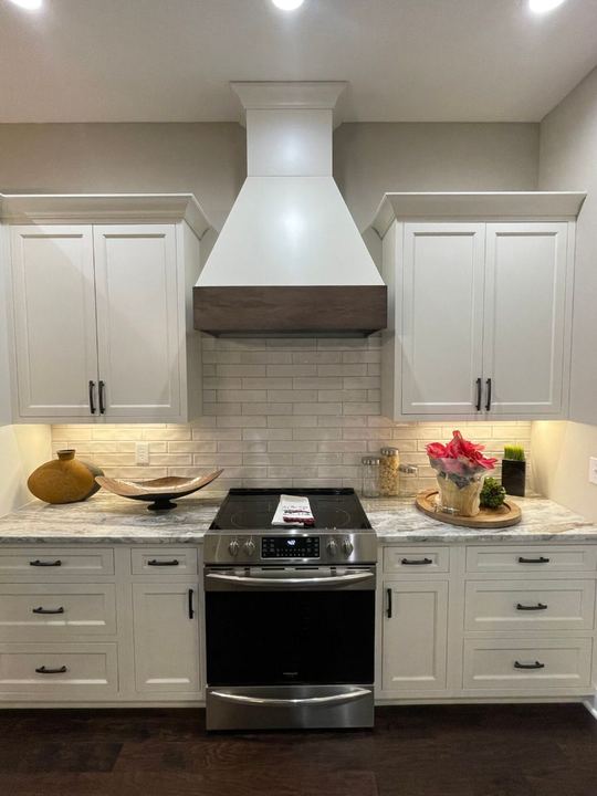 White kitchen with handmade-look subway tile backsplash and granite countertops