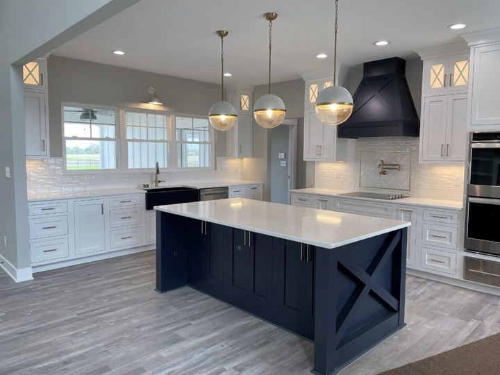 White glazed subway backsplash with gold-framed herringbone accent over the range and gray LVP floors