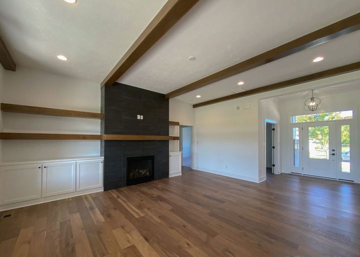 Great room with wide hickory hardwood flooring and floor-to-ceiling black tile fireplace surround
