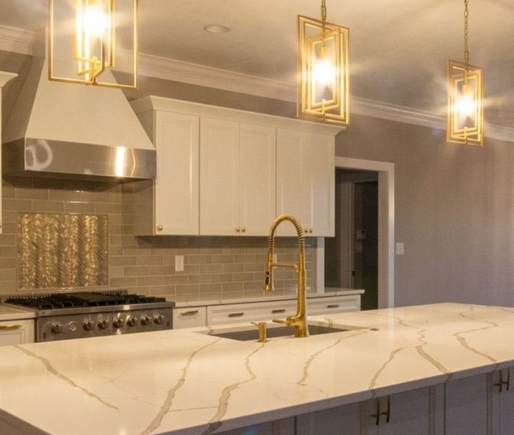 Kitchen with taupe subway backsplash, metallic herringbone accent and brushed gold faucet