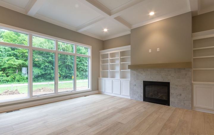 Living room with gray brick-look tile fireplace, built-ins and light oak plank flooring