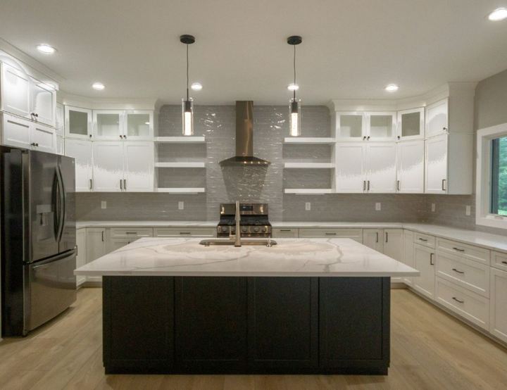 White kitchen with gray glazed subway tile backsplash run to the ceiling, open shelving and quartz island