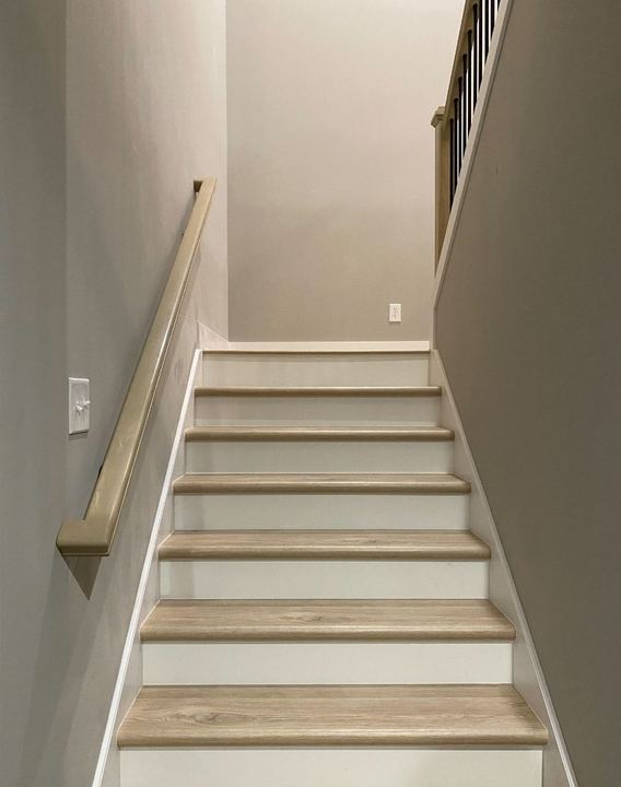 Staircase with light oak wood treads, white risers and matching oak handrail