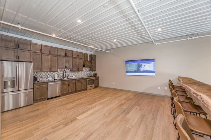 Light white oak hardwood flooring in a garage condo kitchenette with live-edge bar and mosaic backsplash
