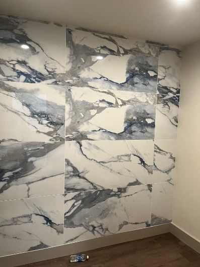 Blue and white marble-look large-format tile accent wall in an office break room