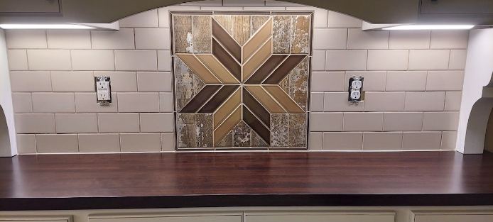 Beige subway backsplash with wood-look quilt-star mosaic accent over a dark walnut hutch counter
